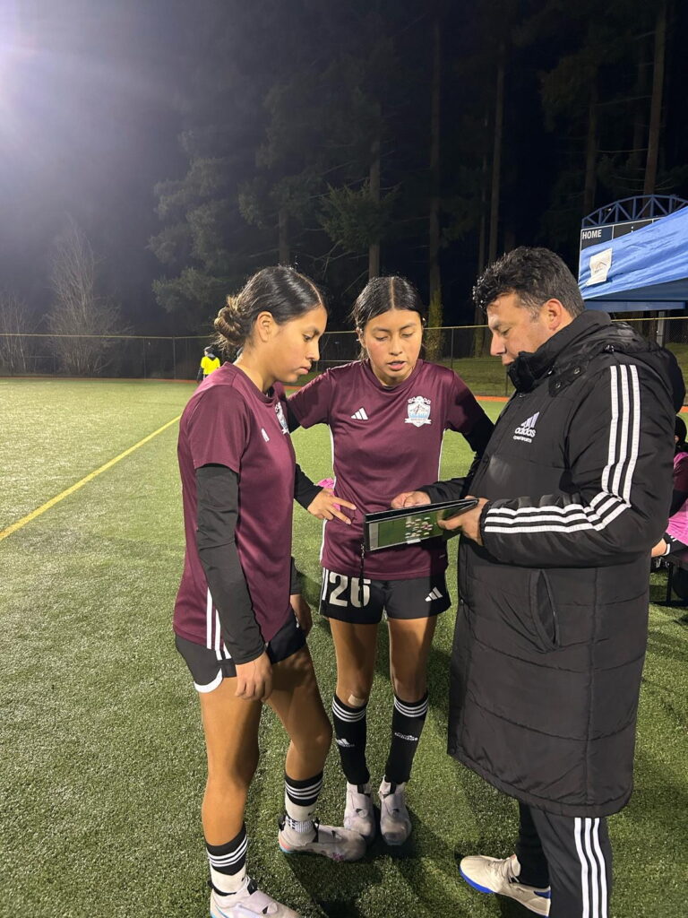 Coach Javier explaining the game plan to two players, Portland youth soccer club