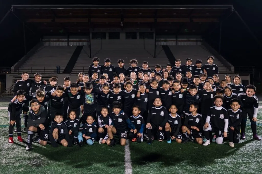 Genesis Futbol Club youth players and coaches team photo at night in Gresham, Oregon